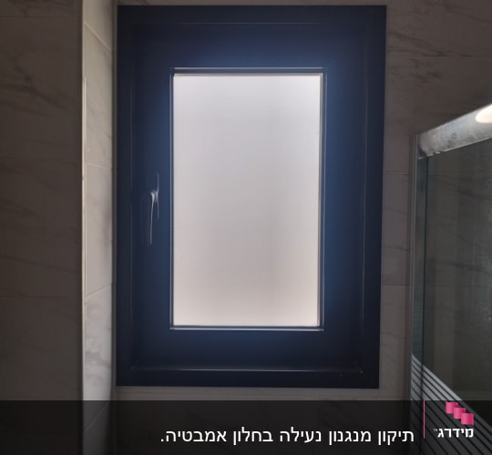 חלון עם מסגרת שחורה וידית בצד שמאל